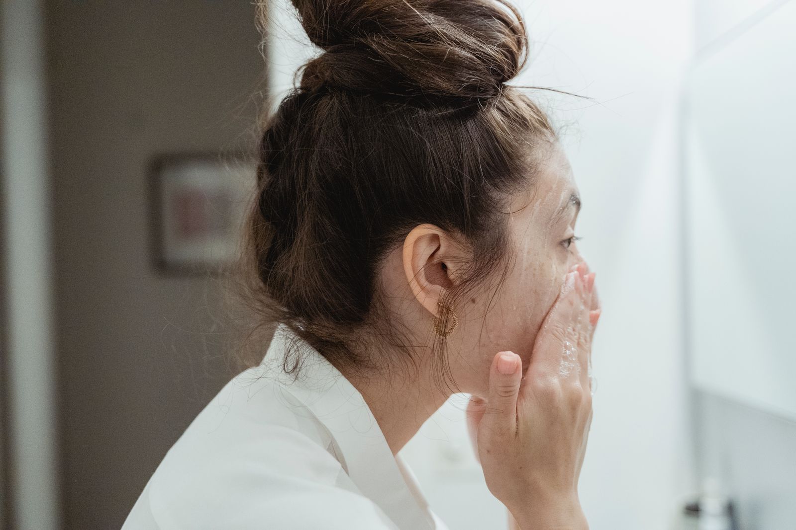 Woman washing her face at a bathroom sink